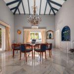 Comedor elegante con lámpara de araña y techos altos en vivienda de La Costa del Sol