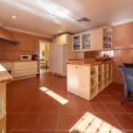 Cocina espaciosa con comedor auxiliar y mobiliario de madera en casa de La Costa del Sol