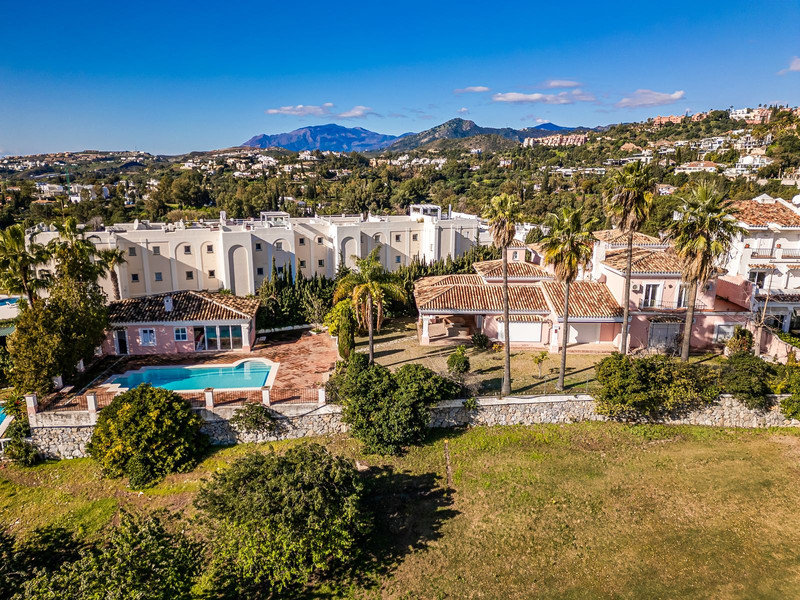 Vista aérea de villa con piscina y palmeras en urbanización de La Costa del Sol