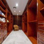 Vestidor con armarios empotrados de madera y suelo de mármol en villa de La Costa del Sol