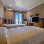 Dormitorio doble con aire acondicionado, televisor y salida a terraza en propiedad de La Costa del Sol