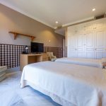 Dormitorio con dos camas individuales, armario empotrado blanco y decoración sobria en vivienda de La Costa del Sol