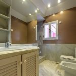 Baño moderno con revestimientos en mármol y paredes en tonos tierra en propiedad de La Costa del Sol