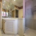 Baño con ducha de mármol, gran espejo y mobiliario blanco en casa de La Costa del Sol