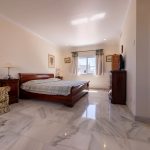 Dormitorio principal con mobiliario de madera y baño en suite en propiedad de La Costa del Sol