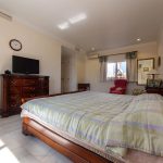 Vista lateral de dormitorio principal con mobiliario clásico de madera en casa de La Costa del Sol