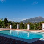 Piscina privada con vistas a la montaña rodeada de vegetación en una villa de La Costa del Sol